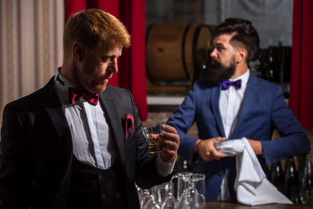 Gentlemans at bar. Bartending. Barman at counter. Hipster in bar. Alcohol beverage.の写真素材