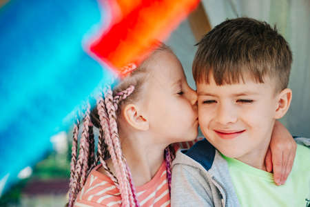 Kids kiss in homemade tent. Backyard party. Best friends spend time. Cute kids camping. Summer fun outdoors.の写真素材