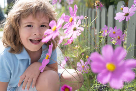 Portrait of a cute child boy with spring flowers. Close up caucasian kids face. Closeup head of funny kid.の写真素材