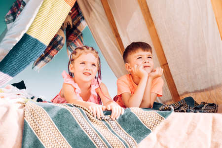 Sister brother relationships. Summer camping. Children in homemade tent. Cute kids camping. Having fun outdoors.の写真素材
