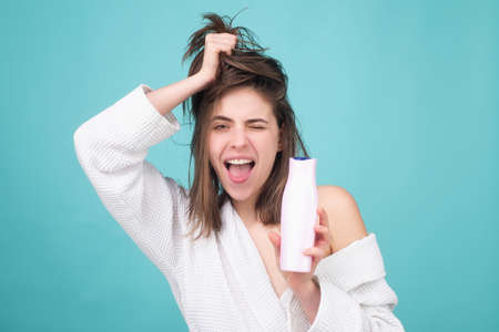 Girl applying hair conditioner. Woman touching her hair. Woman hold bottle shampoo and conditioner.