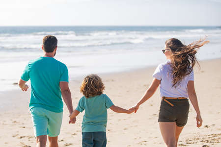 Young family walking on beach. Young happy family having fun together at the sea beach.の写真素材