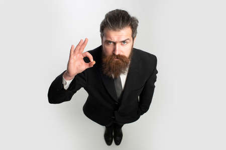 Business man with copy space. Funny handsome businessman in suit with ok sign wide angle.