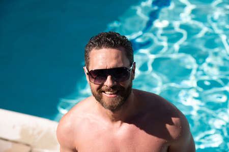 Summer resort. Pool party. Handsome man in swimming pool. Relaxation.の写真素材