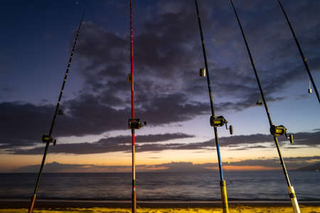 Fishing rod and reel on sea, vacation on blue ocean and summer sunset sky.の写真素材