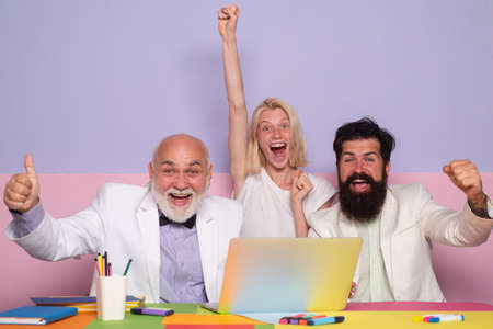 Business team celebrating a triumph with arms up. Excited group of businesspeople during...
