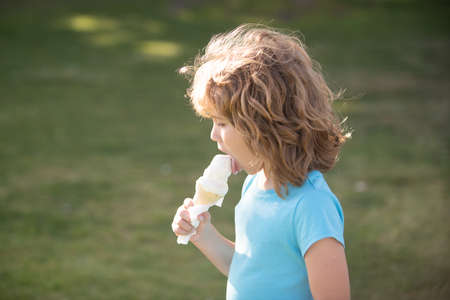 Kids eating ice cream, close up head of cute child.の写真素材