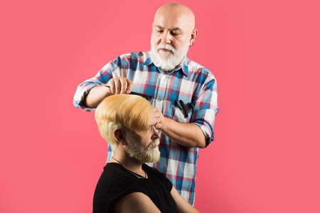 Man at the hairdresser getting a haircut. Modern client in professional hairdressing salon. Professional barber styling hair of his client.の写真素材