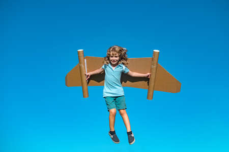 Dreams of travel. Child flying on jetpack with toy airplane on sky background. Happy child boy...