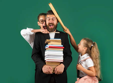 Funny portrait of comic father tutor and crazy students schoolkids on green blackboard background....