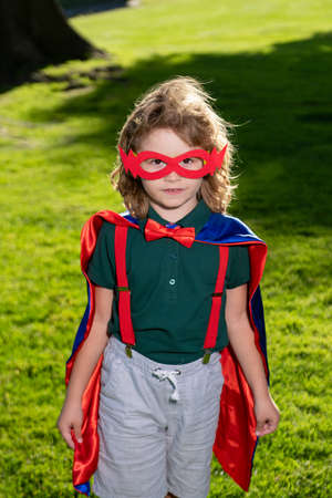 Superhero kid outdoor in park. Child power concept.