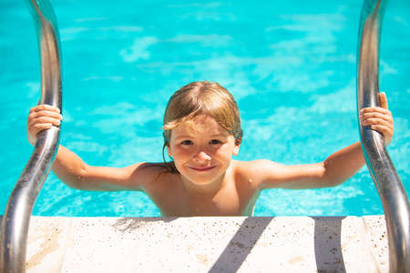 Summer activities for happy child on the pool. Kid boy in summer swimming pool.の写真素材