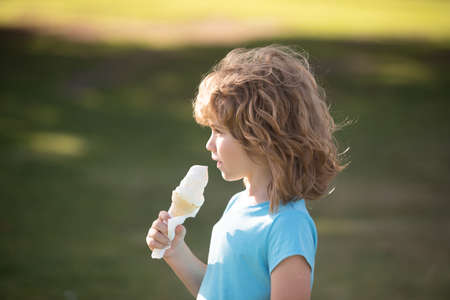 Cute child boy eating ice cream. Close up caucasian kids face. Closeup head of funny kid.の写真素材