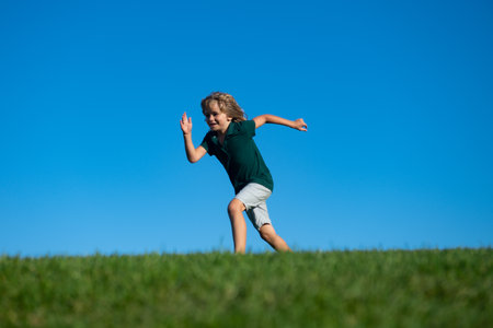 Happy kids playing and running on grass outdoors in summer park. Active kids healthy outdoor. Fun activity.の写真素材