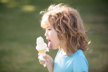 Portrait of a cute child boy eating ice cream. Close up caucasian kids face. Closeup head of funny kid.の写真素材