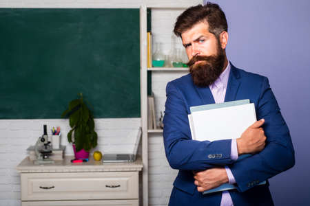Portrait of young male teacher in school classroom. Tutor professor mentor man.の写真素材