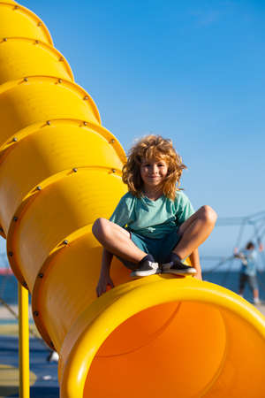 Child on slide playground area. Cute boy in the kids park having fun.の写真素材