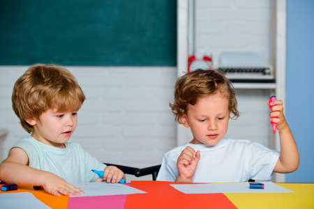 Happy cute clever boys pupils drawing. Kids funny education. Preschool childrenhaving fun. Kids...