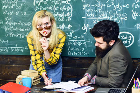 Teacher puts marks sends feedbacks on email with laptop computer. International student making...
