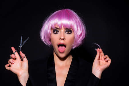 Funny woman with scissors having hair cut. Beautiful girl with straight hair with professional...