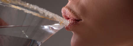 Woman drink cocktail. Banner of close up wet sexy lips. Young girl drinking red lip cocktail closeup.の写真素材