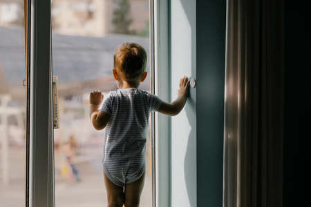 Baby boy on window sillの写真素材