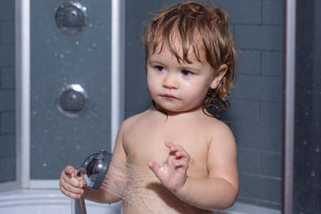 Child bathing. Bathing baby. Happy kid with soap foam on head.の写真素材