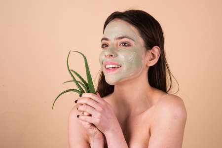 Beautiful woman with aloe vera facial procedure, spa health concept. Skin care beauty treatment. Towel on head. Medical mineral mud.の写真素材