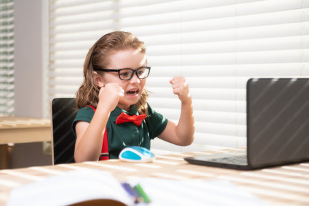 Child boy using a laptop and study online lesson. Pupil at school. Cute child using laptop computer, studying online.の写真素材