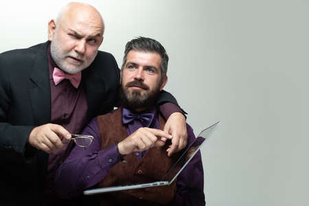 Son teaching mature senior dad to use computer. Adult learning. Son helping grandfather with laptop....
