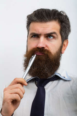 Concentrated man with pen in his mouth. He is thinking. Business concept. Escape from crisis. Funny face. Great Idea.の写真素材