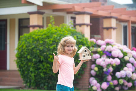 Children with toy house. House in kids hand against new home. Real estate concept. Mortgage, house insurance, future plans, protecting children.の写真素材