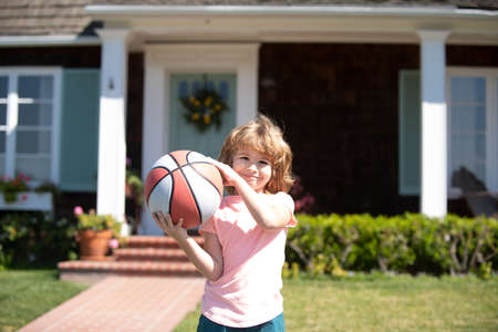Kid playing basketball. Child posing with a basket ball outside.の写真素材