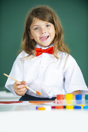 Closeup of little toddler girl drawing picture with colorful paint using brush. Child education. Concept of art and creativity of children.の写真素材