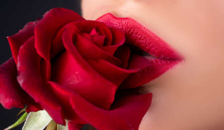 Sensual red lips. Lips with lipstick closeup. Beautiful woman lips with rose. Beautiful woman lips with rose.の写真素材
