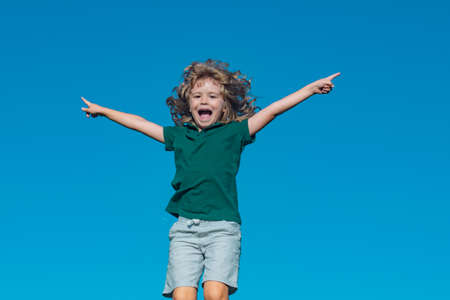 Excited child boy playing on sky in a park at a spring. Laughing, enjoying fresh.の写真素材