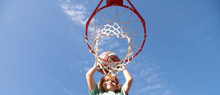 Kid boy playing basketball, banner with copy space. Child playing basketball outdoors shooting slam...