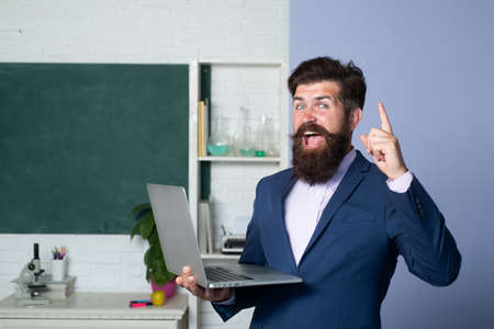 Teacher with laptop notebook having idea. Amazed teacher waiting for students, smiling confidently....