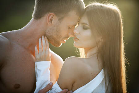 Young couple in love spends time together. Man embracing and going to kiss sensual woman.の写真素材