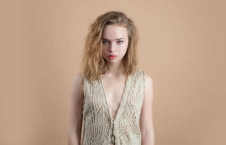 Look at camera. Nude girl knitted vest. Cozy sweater fashion.