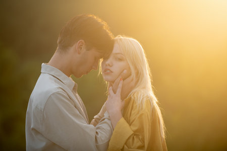 Young couple in love spends time together. Couple lovers hugging and kissing in the park at sunset. Love, youth, happiness concept.の写真素材