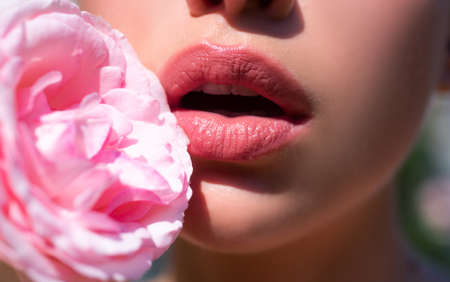 Sensual open mouth. Lips with lipstick closeup. Beautiful woman lips with rose.の写真素材