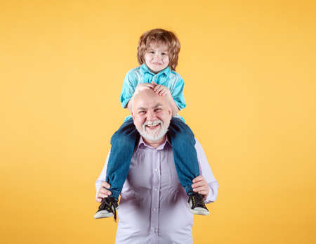 Grandfather and grandson piggy back ride with funny face isolated. Elderly old relative with child.の写真素材