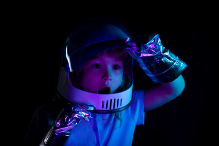A little boy dreams of becoming an astronaut and flying into space. Cosmos childrens in spacesuit...