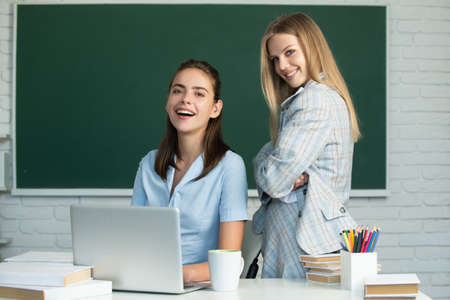 Students girls talking each other in classroom at college. Learning and preparing for exam with friends.の写真素材