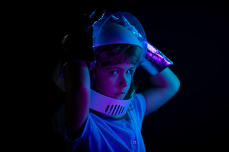 Close up kids portrait isolated on black, adventure imagination. Child boy playing astronaut with spaceman.の写真素材