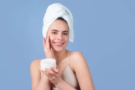 Cosmetic products. Closeup face of beautiful young woman with bath towel on head. Beautiful woman face isolated on studio. Natural cosmetics and skincare. Beautiful woman woman in spa salon.の写真素材