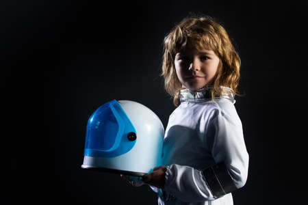 Cute little boy spaceman child in space suit holding helmet on black background. Kids imagining of space.の写真素材