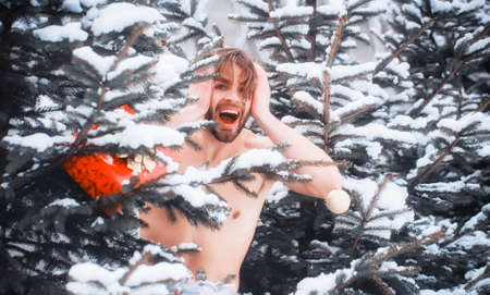 Excited nude man on winter day. Athlete guy with naked torso, muscles in snow. Healthy lifestyle concept. Christmas, new year, holidays celebrationの写真素材