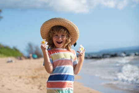 Portrait of little boy in straw hat on summer beach. Concept of kids face close-up. Head shoot children portrait. Summer holiday.の写真素材